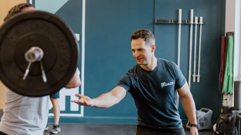 Coach cueing a new member's barbell position during a one-on-one Foundations session at CrossFit Spring Hill